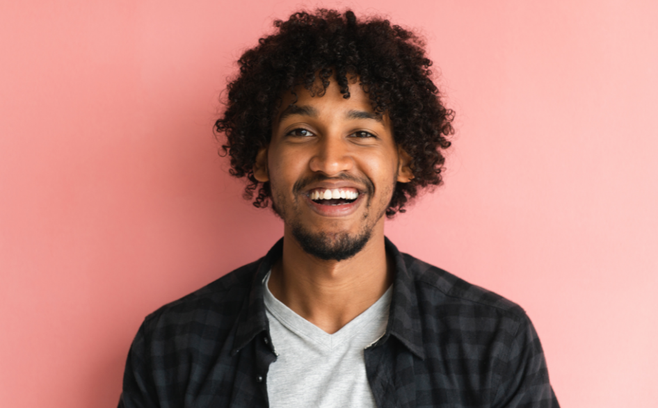 mixed race smiling man pink background