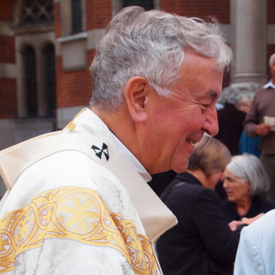Photo of Cardinal Vincent Nichols outside church smiling in a crowd