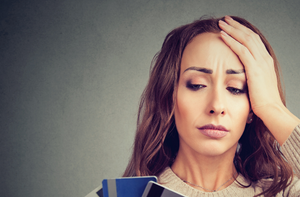 worried woman looking at bank cards